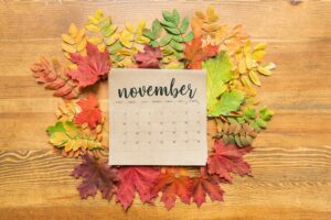 November calendar sheet surrounded by autumn leaves of various colors