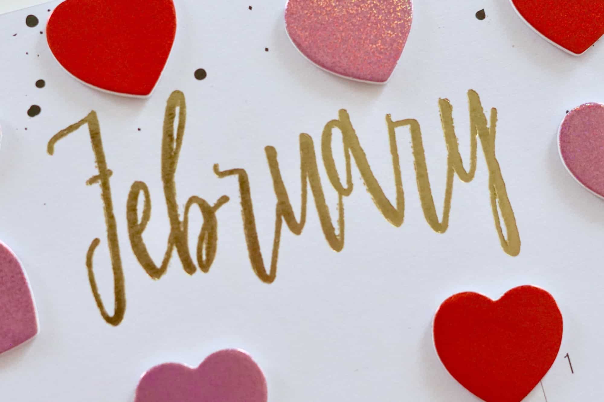 February in gold letters surrounded by pink and red hearts